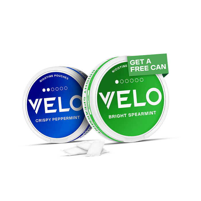 Velo Nicotine Pouches |  Two round cans of VELO nicotine pouches, one blue-labeled Crispy Peppermint and one green-labeled Bright Spearmint with a “Get a Free Can” sticker. Two white Velo pouches are placed in front.