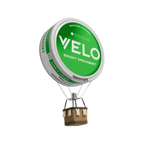 Velo Nicotine Pouches |  A hot air balloon with a green VELO Bright Spearmint nicotine pouch as the balloon and a wicker basket hanging below, isolated on a white background. This creative design highlights Velo nicotine pouches in a playful and imaginative way.