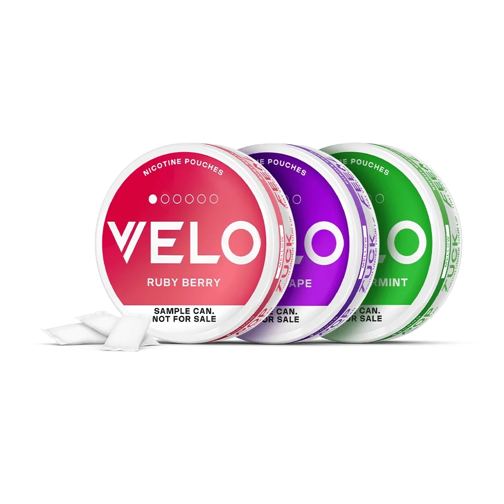 Velo Nicotine Pouches |  Three round cans of VELO nicotine pouches in Ruby Berry, Purple Grape, and Mint flavors. Each can is open with nicotine pouches visible, and labeled SAMPLE CAN. NOT FOR SALE on a white background.