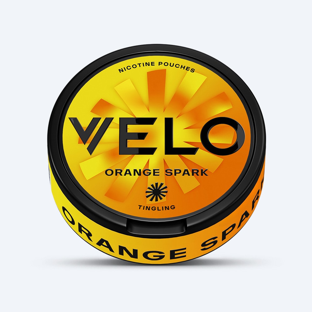 Velo Nicotine Pouches |  A round container labeled VELO Orange Spark nicotine pouches features an orange and yellow lid with a sunburst design. The words "Tingling" and "Nicotine Pouches" are displayed on the packaging. VELO Orange Spark promises an intense tingling sensation combined with a vibrant, citrusy experience inspired by zesty ripe oranges.