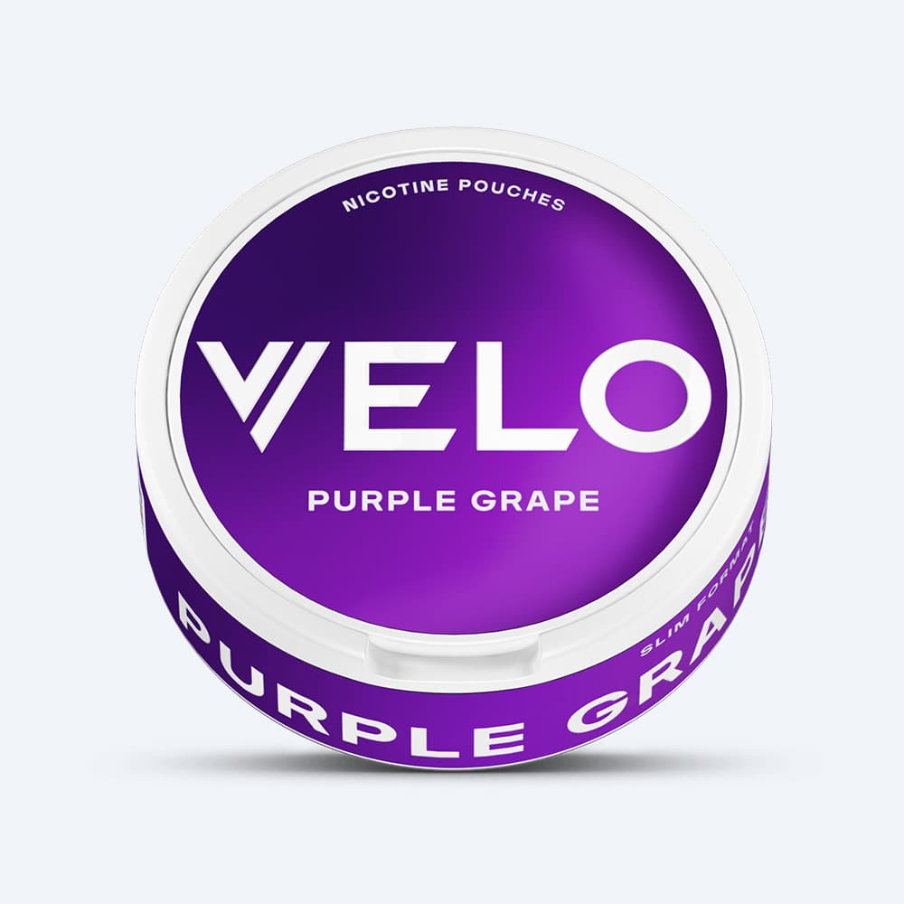 Velo Nicotine Pouches |  A round container of VELO Purple Grape Nicotine Pouches, featuring a purple and white design that highlights the rich flavor of red grapes, is displayed against a plain light background.