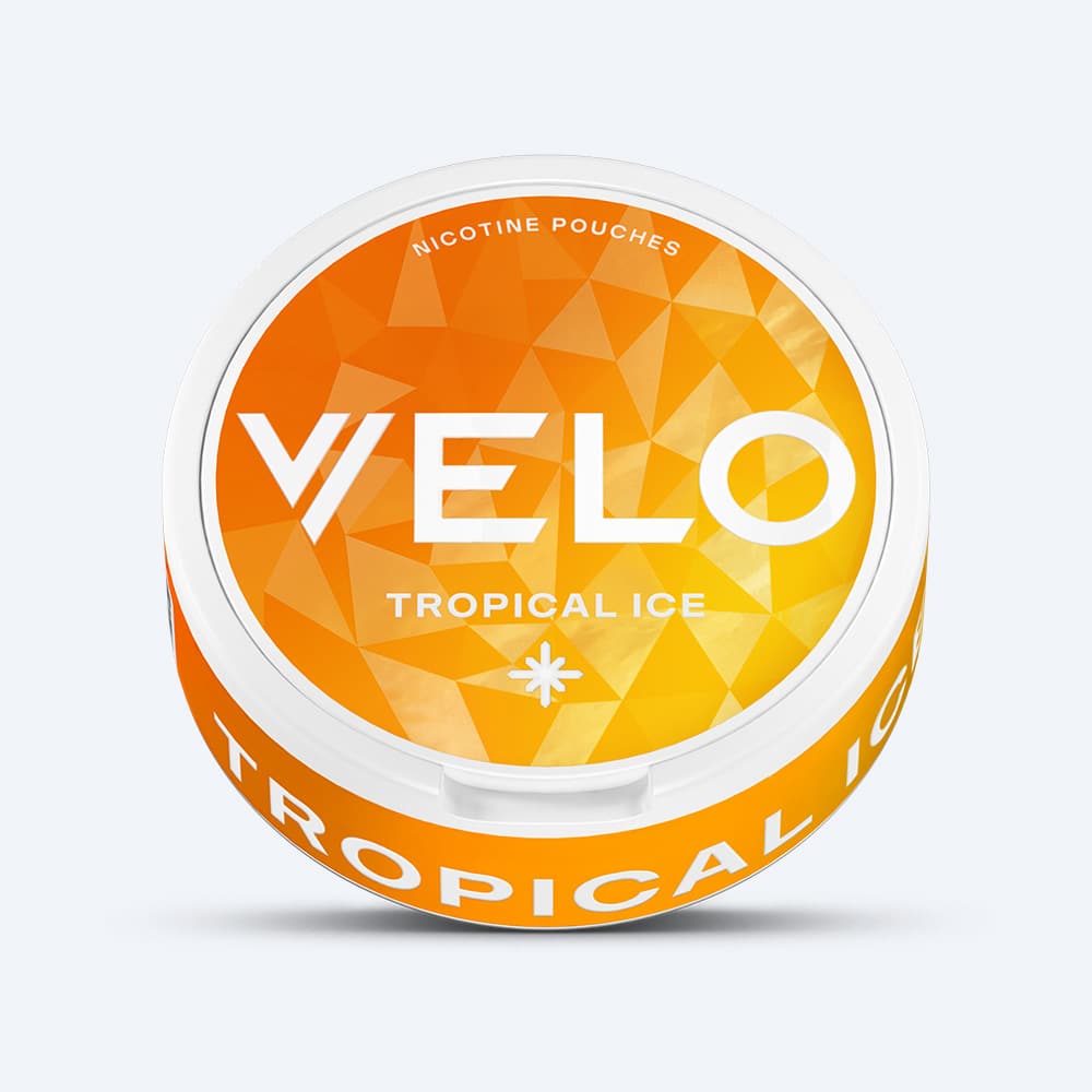 Velo Nicotine Pouches |  A round container of VELO Tropical Ice nicotine pouches featuring an orange, geometric-patterned lid with bold white branding. The side of the container displays "TROPICAL ICE" in white lettering, emphasizing its vibrant fruit flavor and refreshing cooling effect.