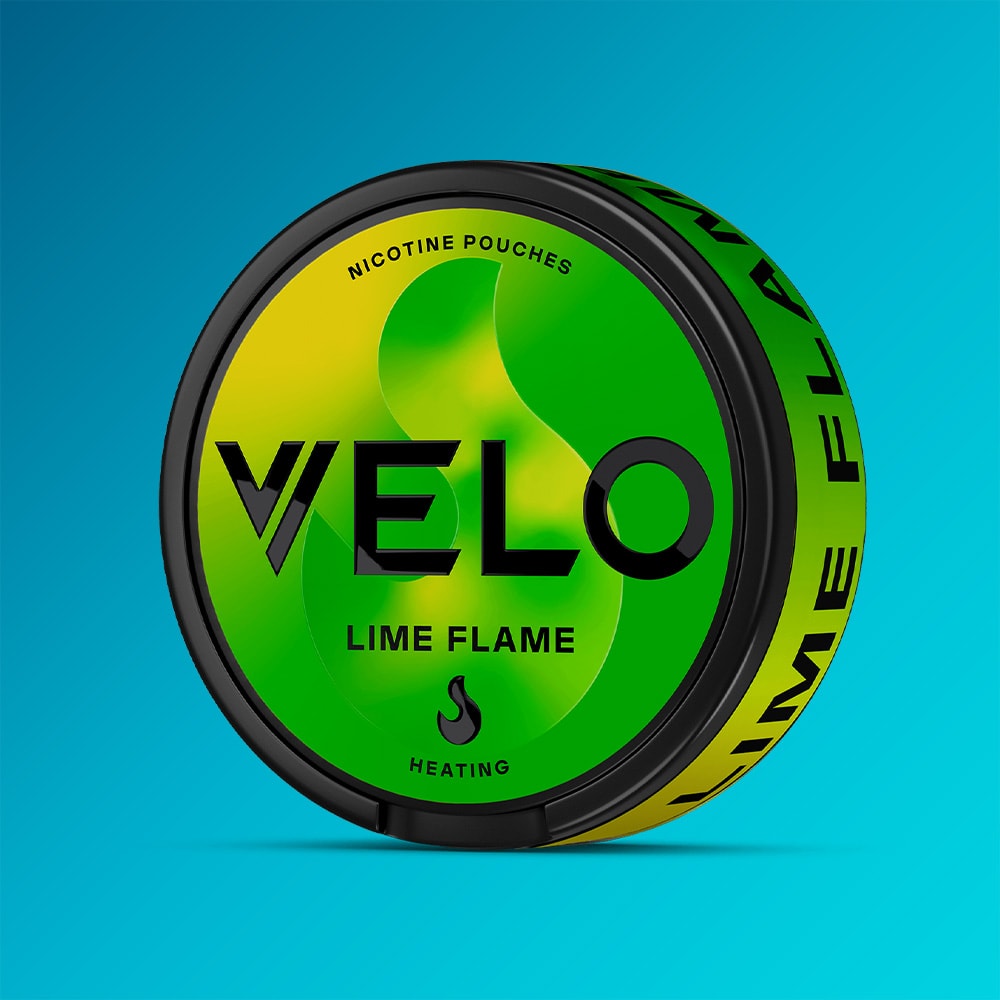 Velo Nicotine Pouches |  A round tin of VELO Lime Flame nicotine pouches, featuring a green and yellow design with bold black text and infused with the zesty kick of aromatic jalapeno, sits on a blue gradient background.