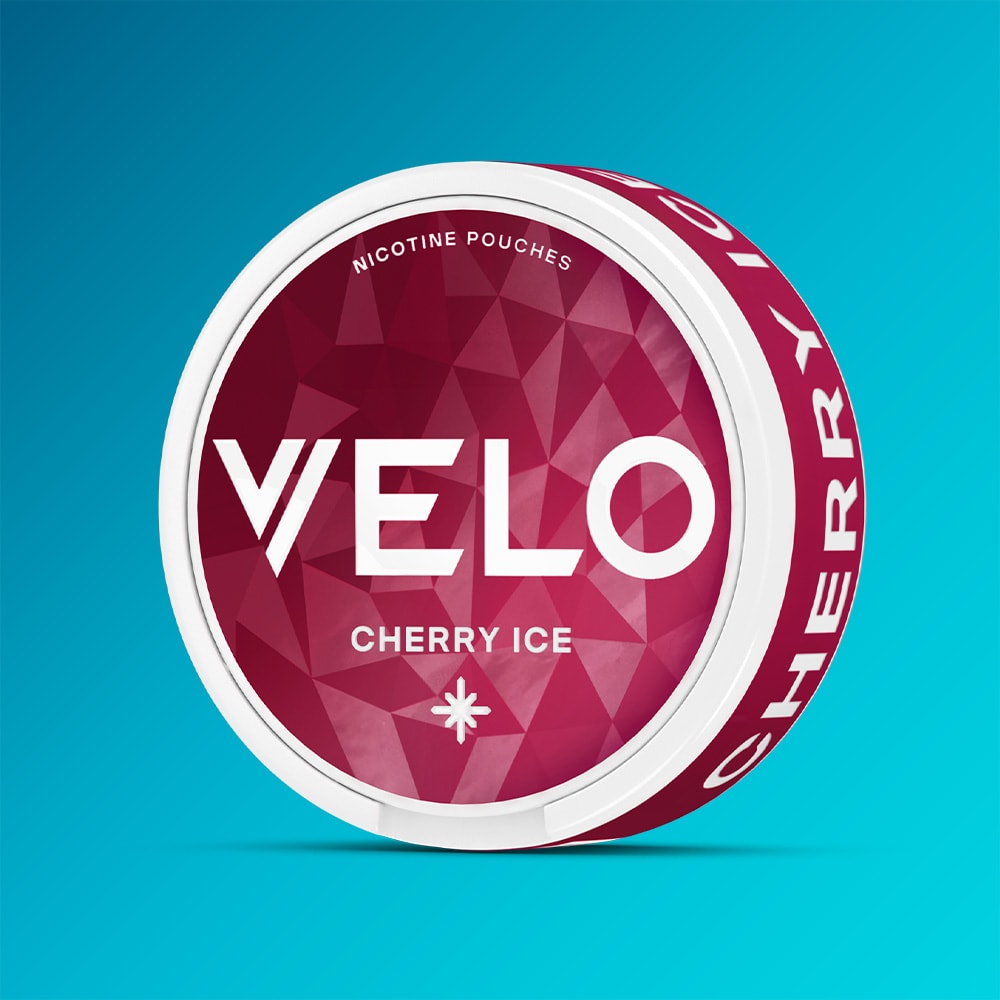 Velo Nicotine Pouches |  A round can of VELO Cherry Ice features a striking red geometric design, white text, and a blue gradient background, delivering an invigorating cherry ice fruit flavor with a refreshing cooling sensation.