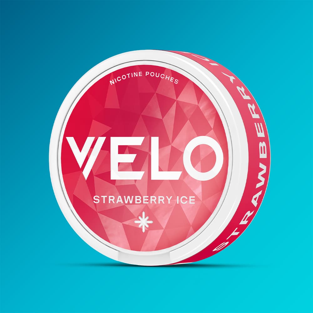Velo Nicotine Pouches |  A round container of VELO Strawberry Ice, adorned with a striking red and white geometric design set against a blue background, highlights these fruity nicotine pouches for a refreshing experience.