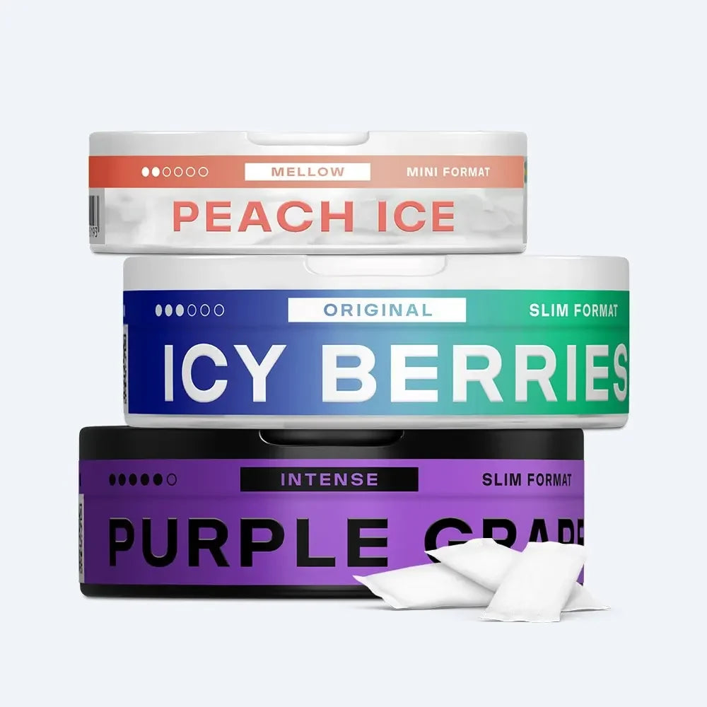 Velo Nicotine Pouches |  Three round Velo tins labeled Peach Ice, Icy Berries, and Purple Grape are stacked with two white nicotine pouches beside them. Each tin displays its flavor, intensity, and format.